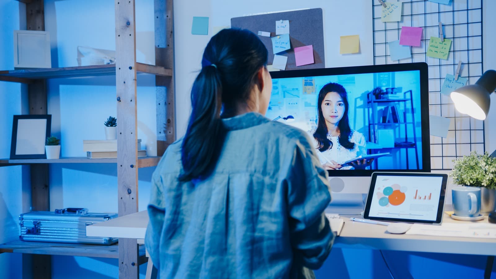 Businesswoman talking with a colleague over a desktop video call in a home office